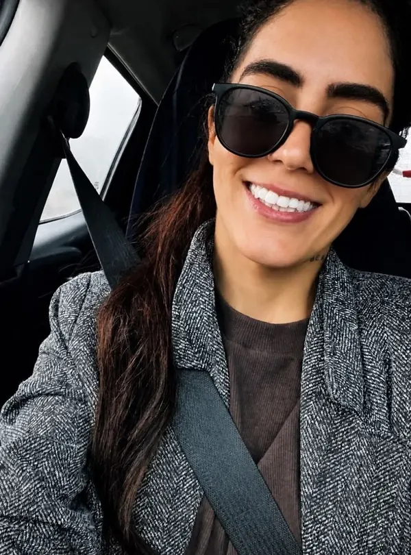 Nora Pinho sorrindo, de óculos escuros